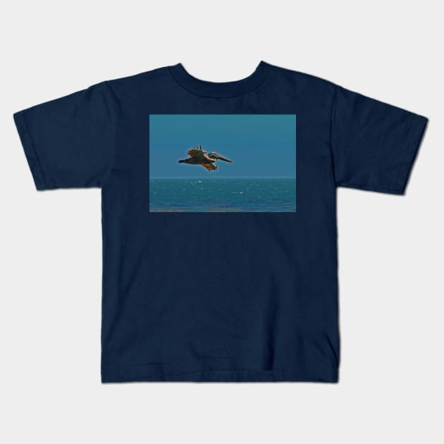 Pelican in flight Kids T-Shirt by wanungara